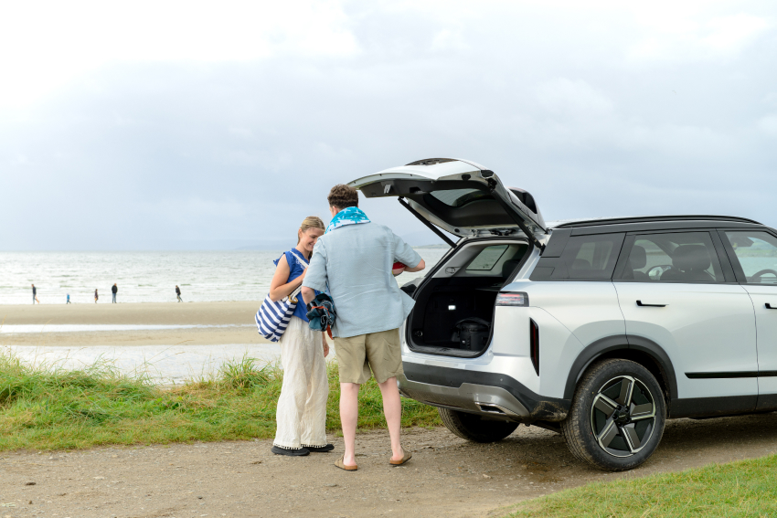 Couple at the beachside, putting items into the boot of a JAECOO 7