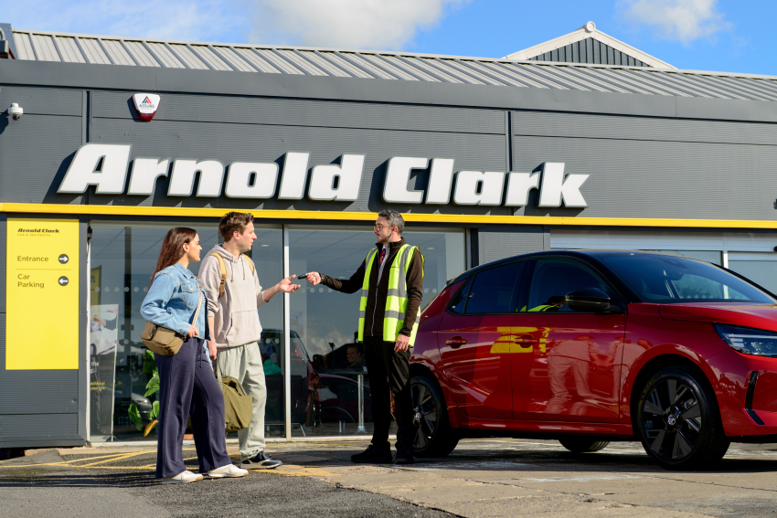 Arnold Clark Rental staff member handing over vehicle keys to young couple