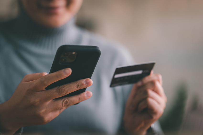 Person holding phone and payment card